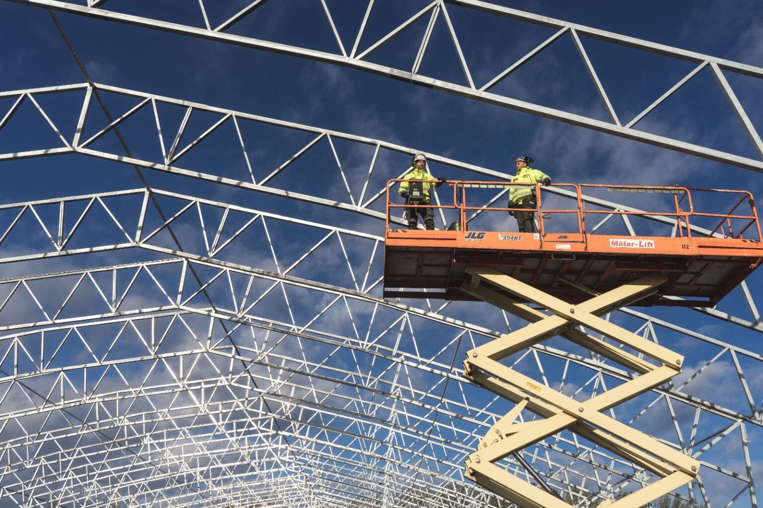 Electric scissor lift in Abu Dhabi positioned on a construction site ready for operator use