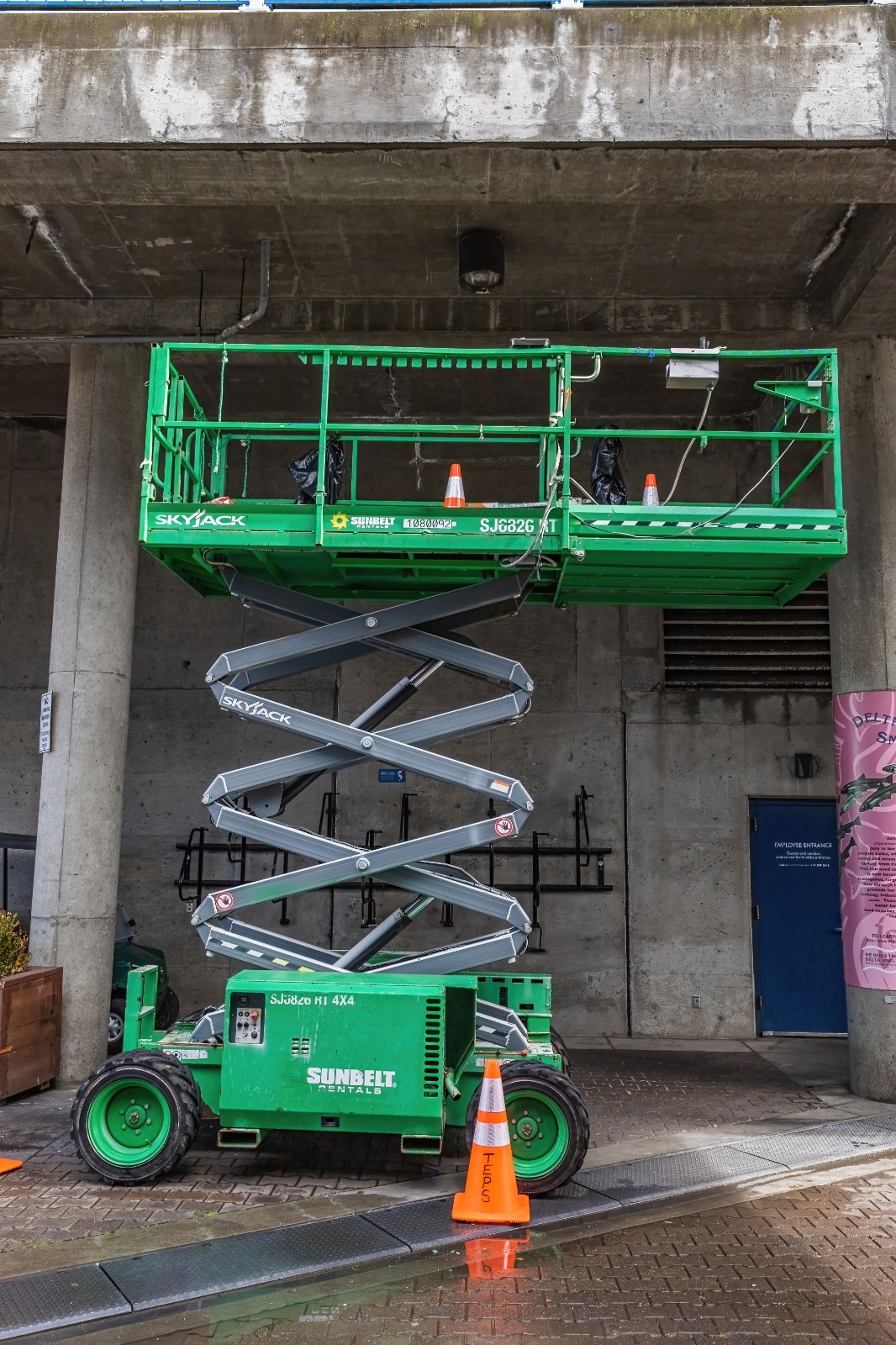 Electric scissor lift RAK model deployed indoors at a warehouse facility for maintenance and installation work