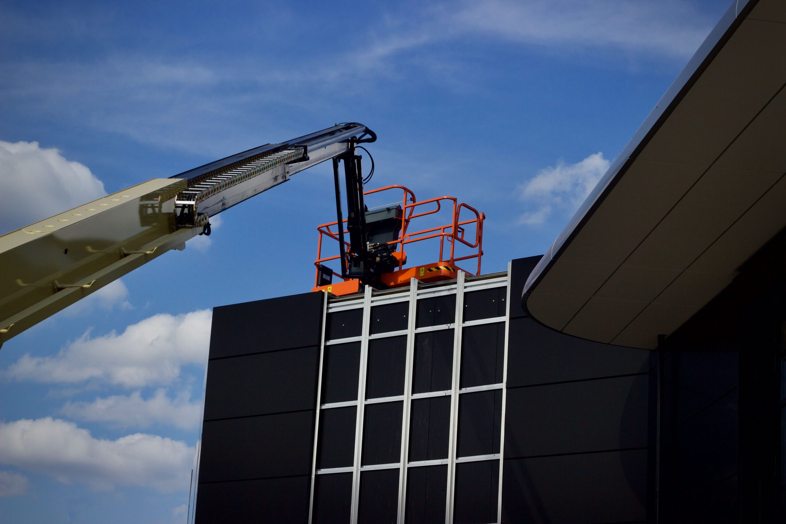 Electric scissor lift in Ajman warehouse being used for high-level maintenance access work