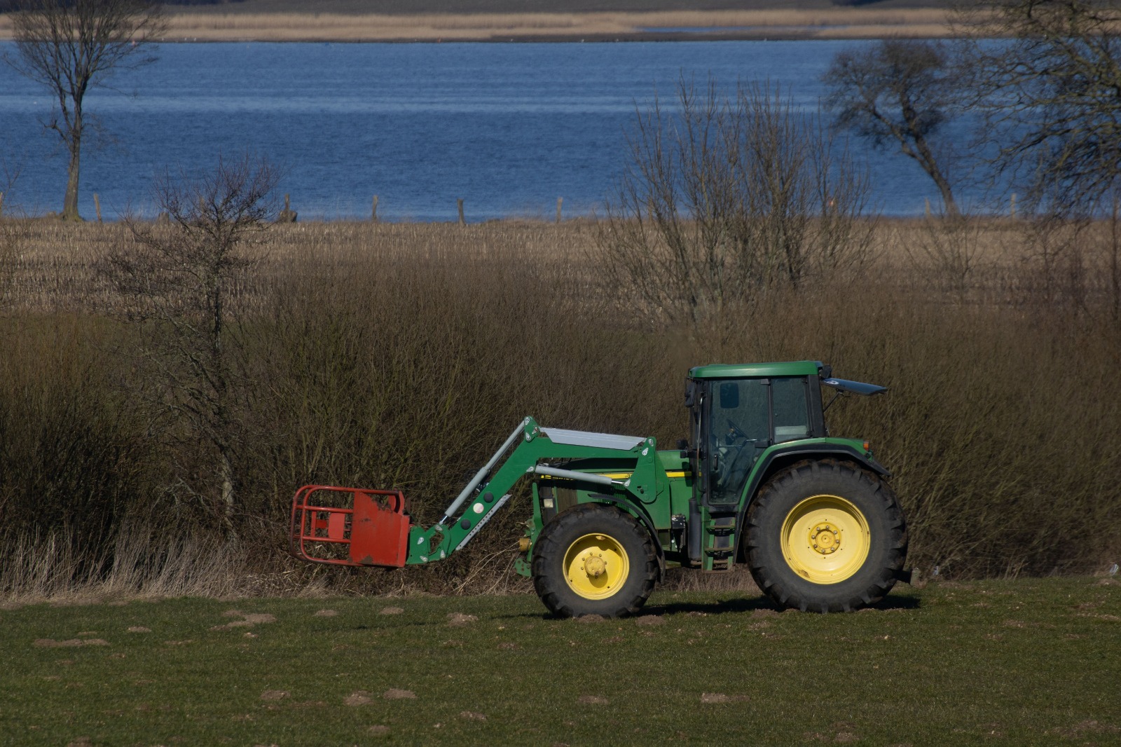 Agricultural tractor for sale in Ajman parked on a farm field, ready for delivery to UAE buyers.